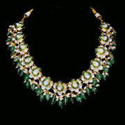 Polki artistry with green stone and pearl embellishments. Necklace